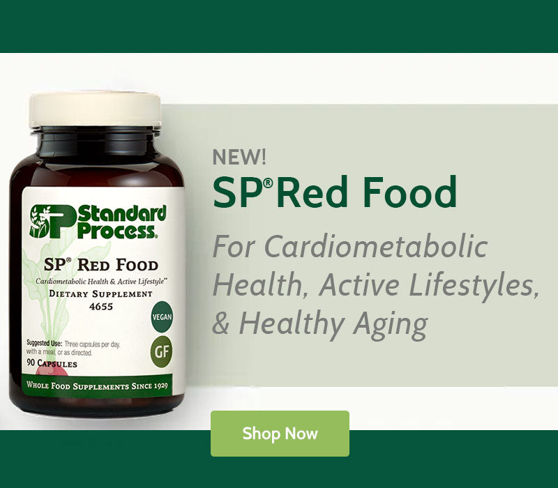 Supplement bottle labeled 'SP Red Food' by Standard Process with promotional text on a green and beige background.